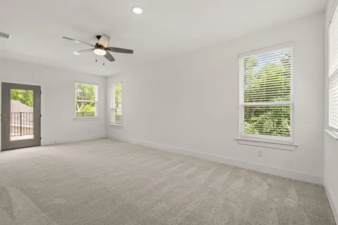 a view of an empty room with a ceiling fan and window