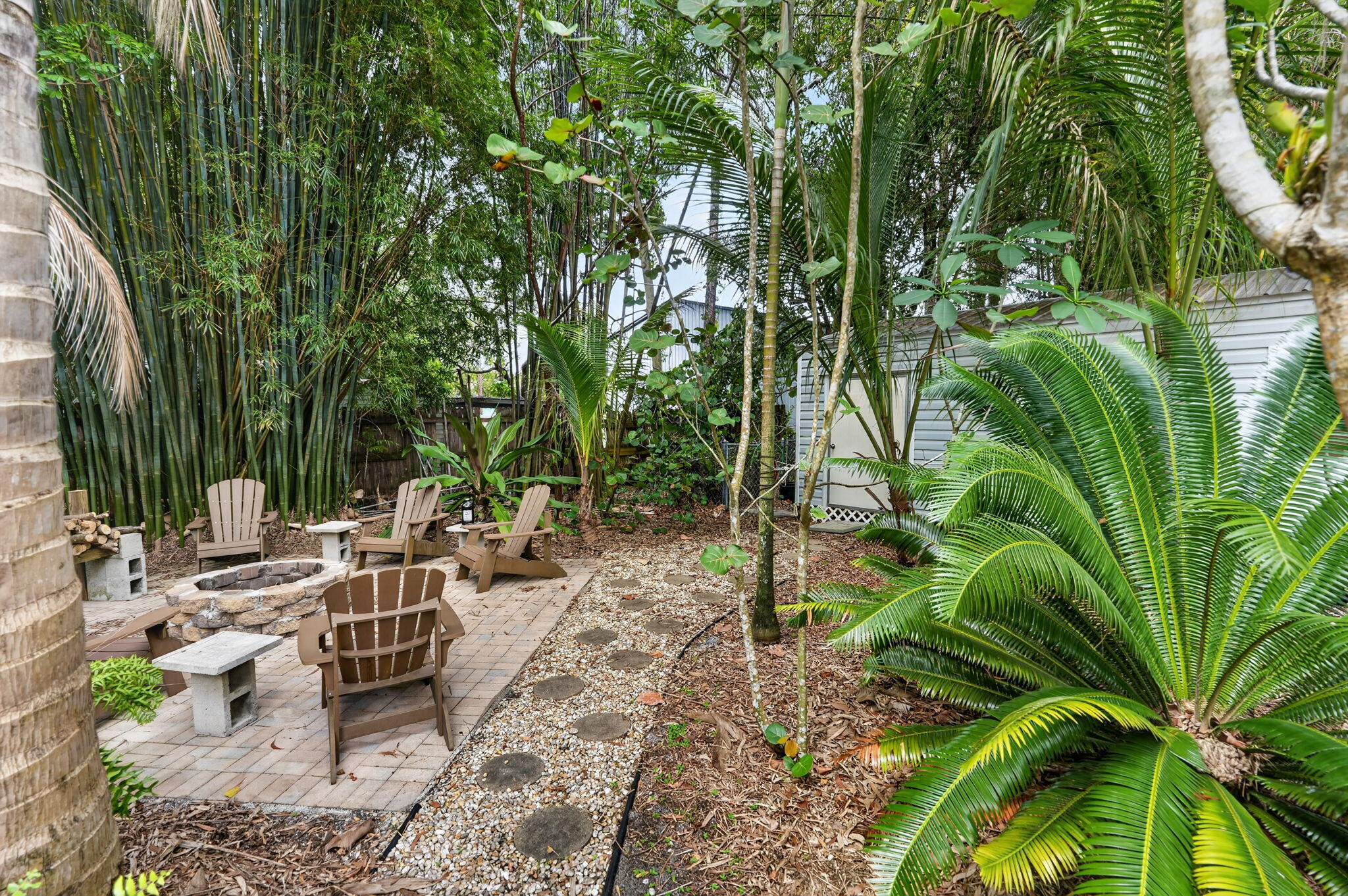17391 Alexander Run Jupiter, FL 33478 - Photo 41 of 55 a view of a backyard with plants and a lawn chairs with plants