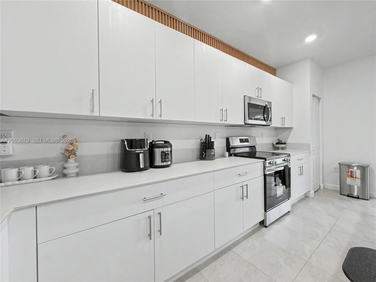 13218 Southwest 189th Terrace Miami, FL 33177 - Photo 23 of 47 a kitchen with granite countertop white cabinets and stainless steel appliances