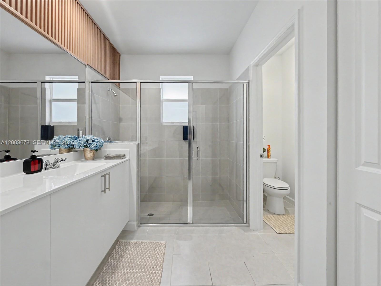 13218 Southwest 189th Terrace Miami, FL 33177 - Photo 32 of 47 a bathroom with a shower sink vanity and mirror