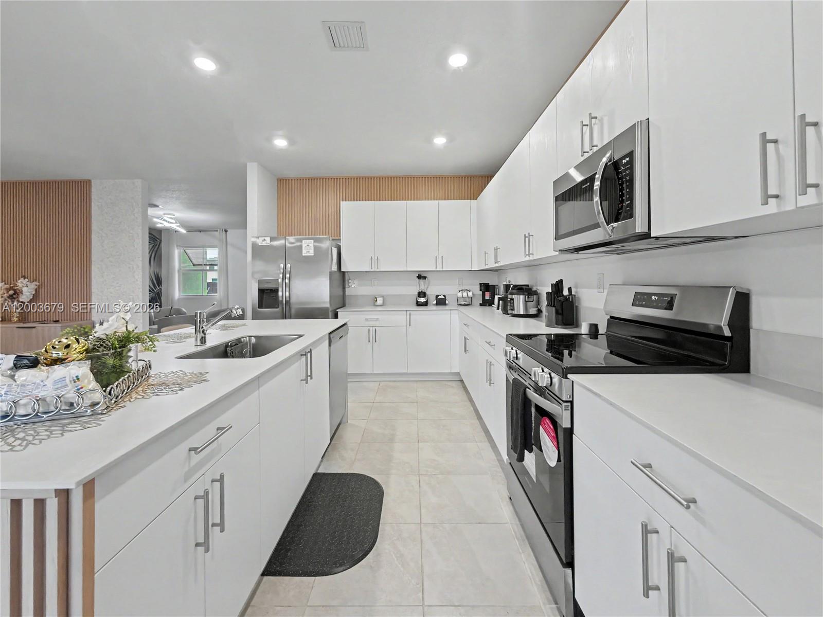 13218 Southwest 189th Terrace Miami, FL 33177 - Photo 4 of 47 a kitchen with stainless steel appliances granite countertop lots of counter top space sink and cabinets