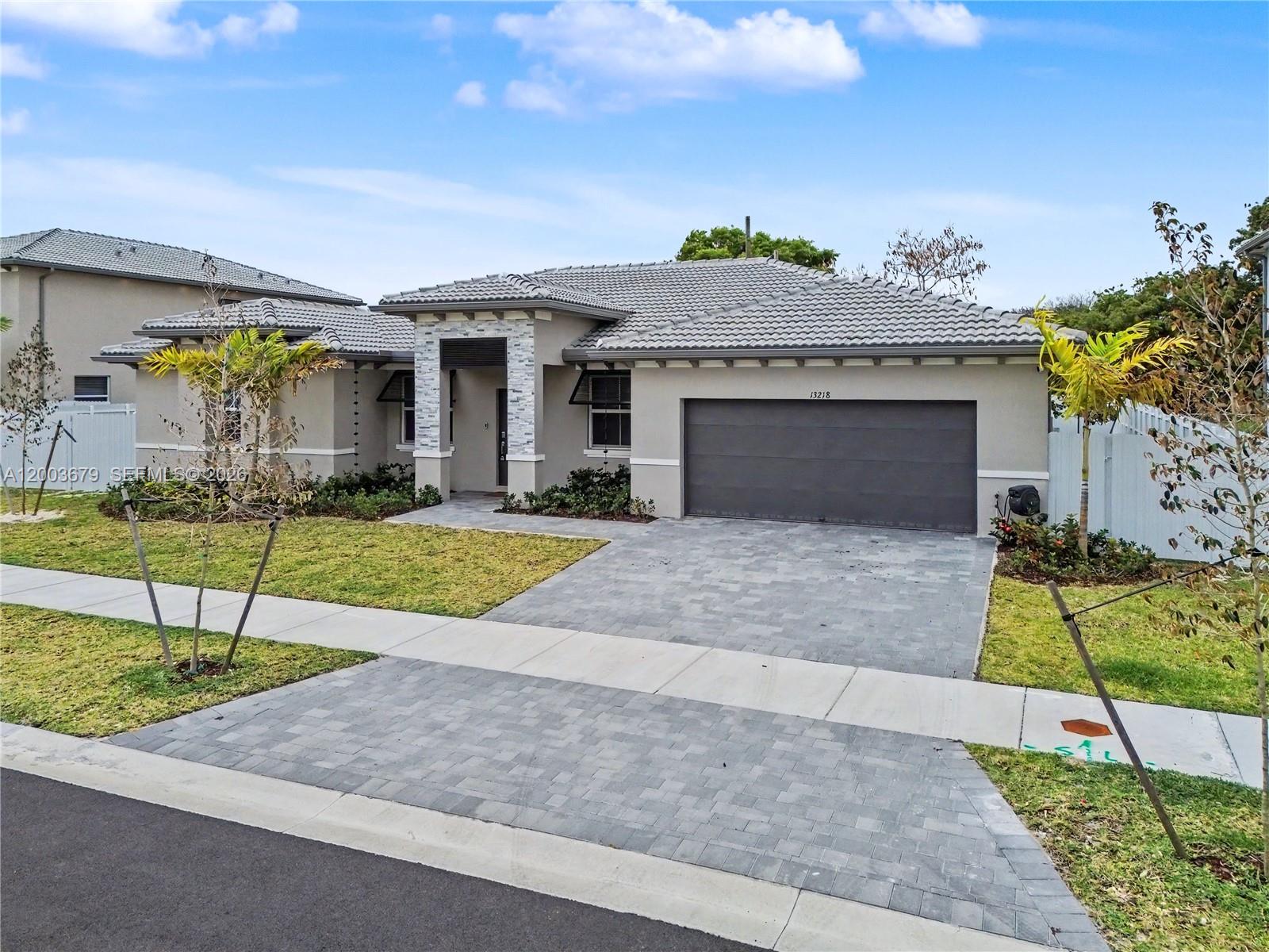 13218 Southwest 189th Terrace Miami, FL 33177 - Photo 6 of 47 a front view of a house with a yard
