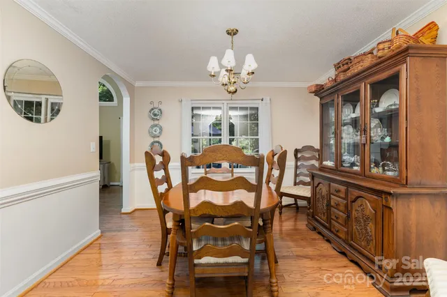 a view of a dining room with furniture a chandelier and wooden floor
