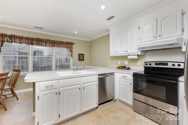 a kitchen with white cabinets and sink