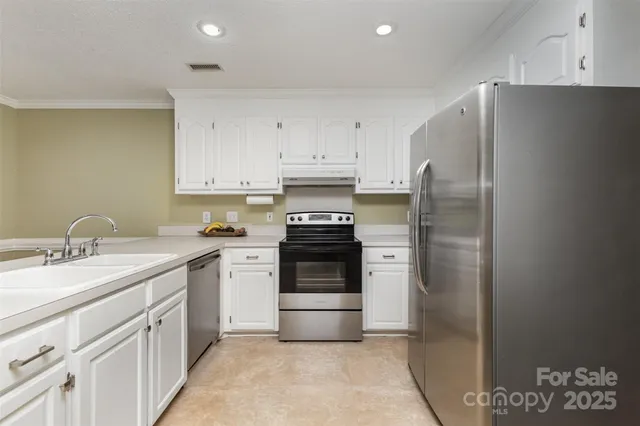 a kitchen with stainless steel appliances granite countertop a refrigerator and a stove