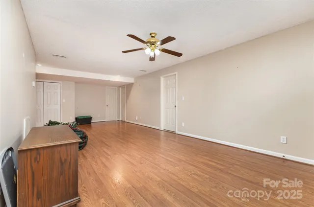a view of empty room with wooden floor