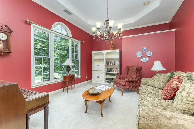 a living room with furniture chandelier and a large window