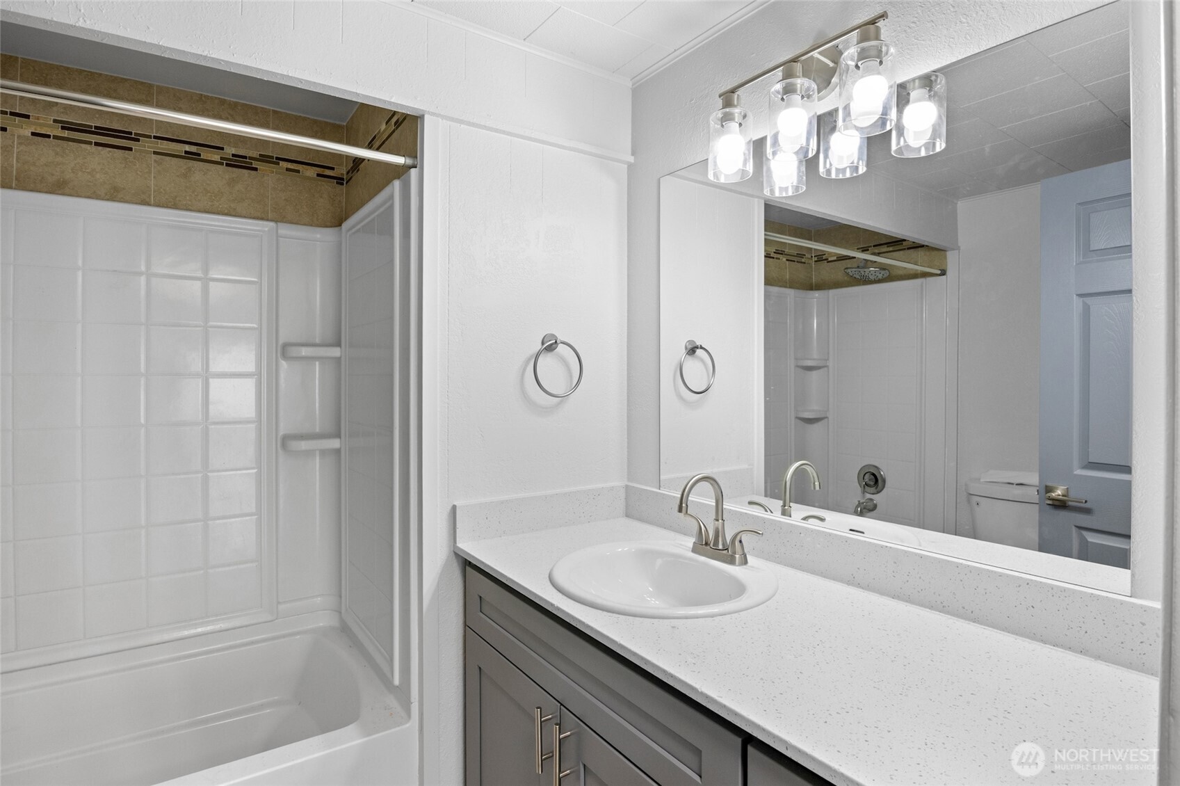 8915 Wilkensen Road Southeast, Unit 3 Yelm, WA 98597 - Photo 12 of 16 a bathroom with a sink a mirror and a shower
