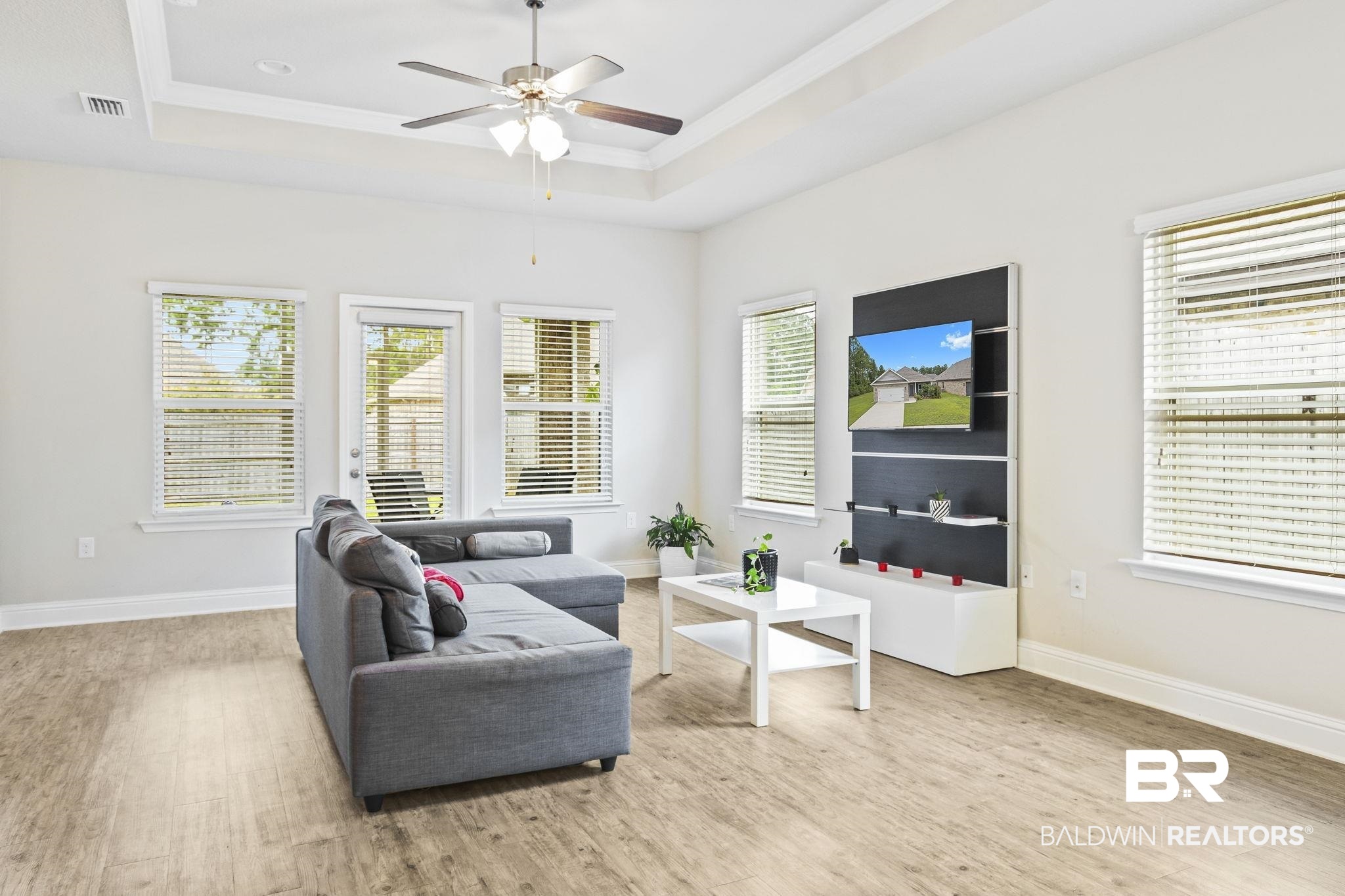31643 Kestrel Loop Daphne, AL 36527 - Photo 5 of 59 Living room with a tray ceiling, ceiling fan, and light hardwood / wood-style floors