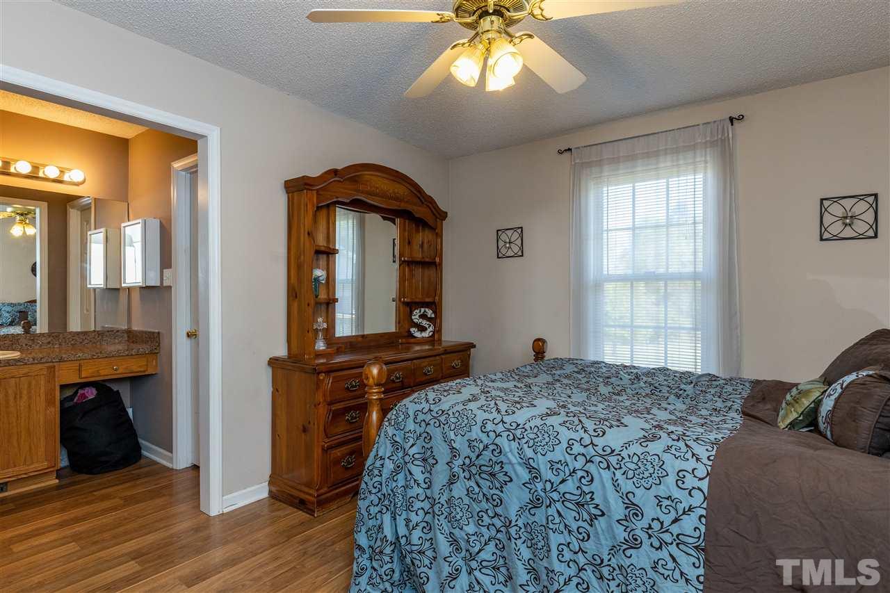 103 Holly Ranch Court Willow Spring, NC 27592 - Photo 17 of 30 a bedroom with a bed and a chandelier