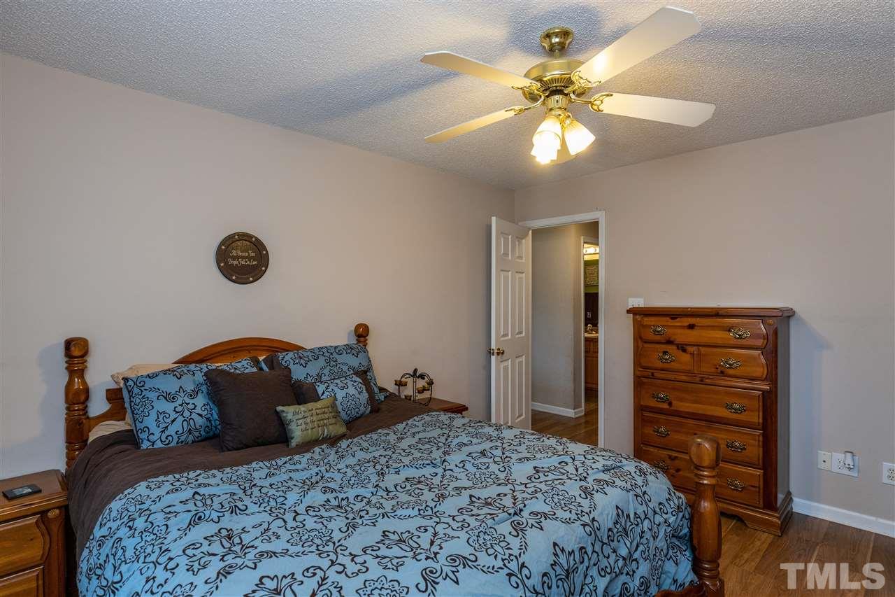 103 Holly Ranch Court Willow Spring, NC 27592 - Photo 18 of 30 a bedroom with a bed and a chandelier
