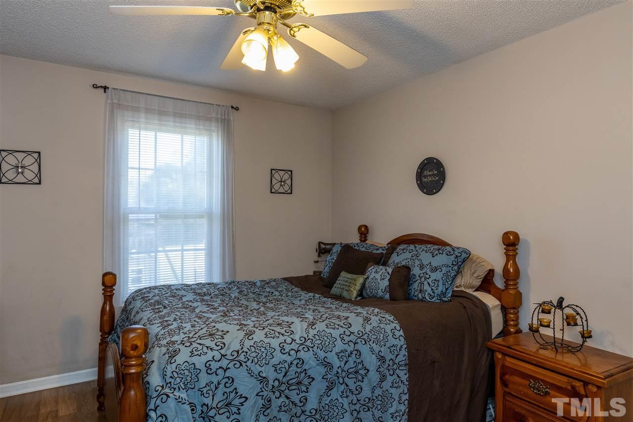103 Holly Ranch Court Willow Spring, NC 27592 - Photo 19 of 30 a bedroom with a bed and a chandelier