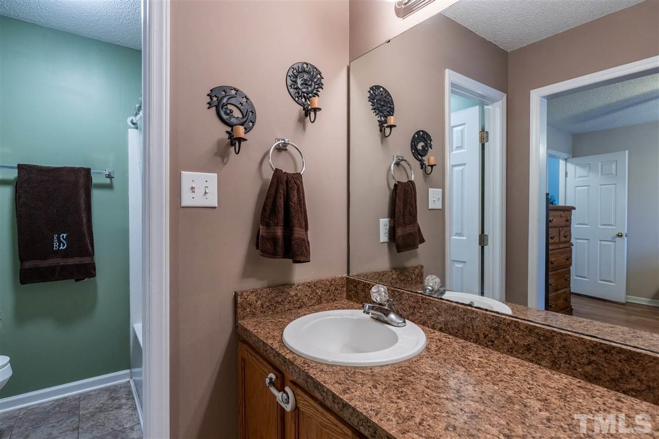 103 Holly Ranch Court Willow Spring, NC 27592 - Photo 20 of 30 a bathroom with a granite countertop sink and a mirror