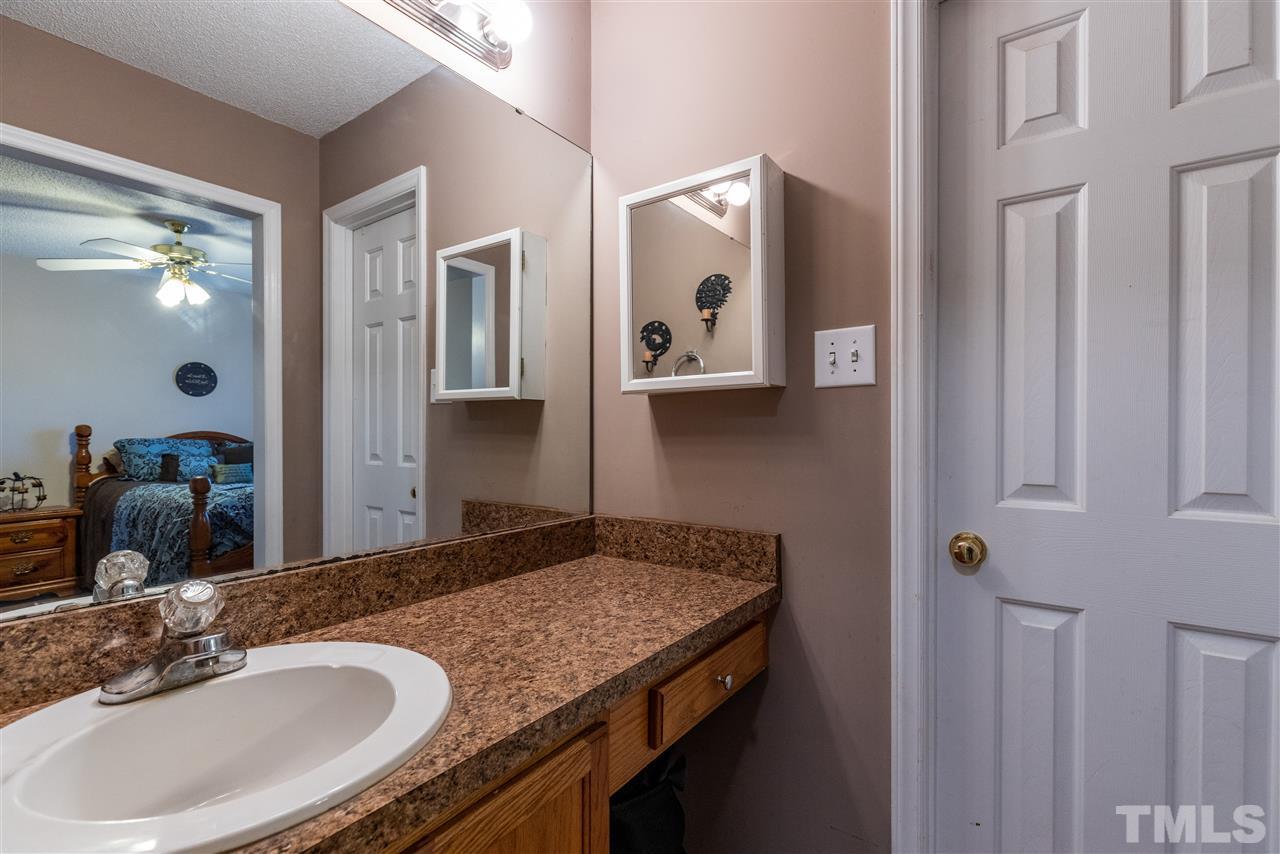 103 Holly Ranch Court Willow Spring, NC 27592 - Photo 21 of 30 a bathroom with a granite countertop sink and a mirror