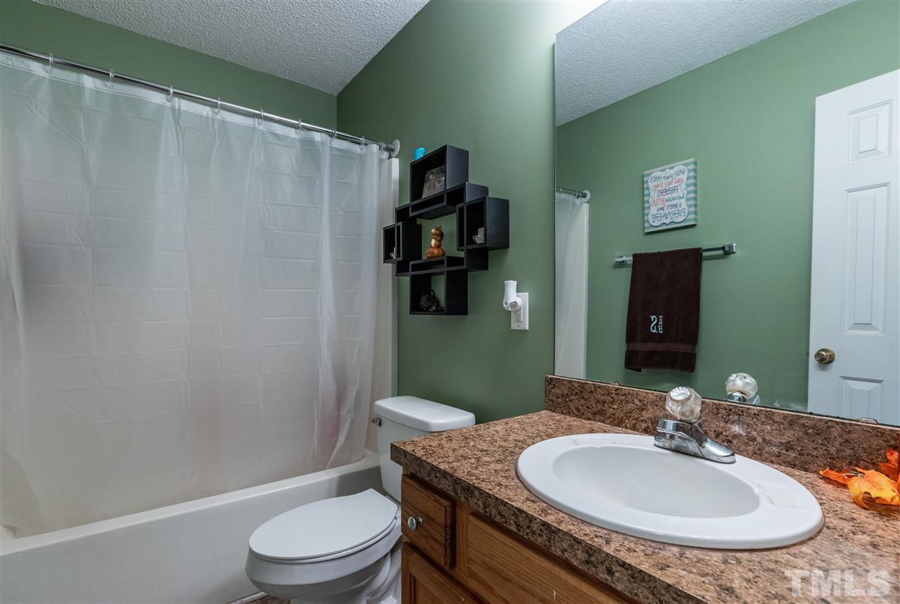 103 Holly Ranch Court Willow Spring, NC 27592 - Photo 22 of 30 a bathroom with a granite countertop sink toilet and a mirror