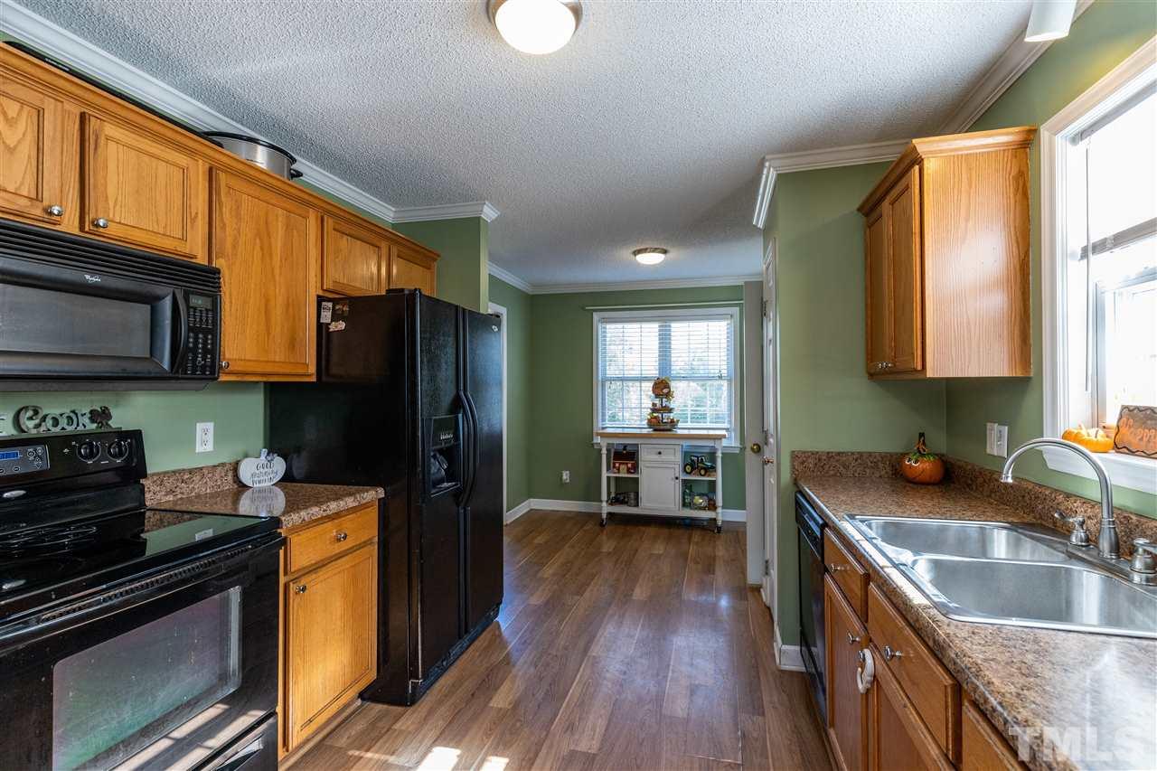 103 Holly Ranch Court Willow Spring, NC 27592 - Photo 8 of 30 a kitchen with stainless steel appliances granite countertop a refrigerator stove top oven and sink