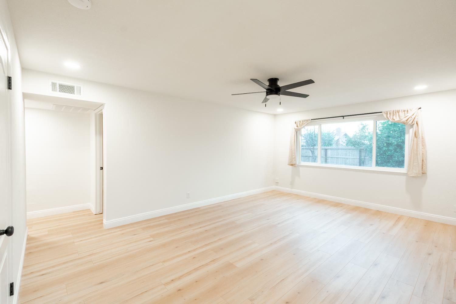 2612 Renn Avenue Clovis, CA 93611 - Photo 3 of 36 an empty room with wooden floor and windows