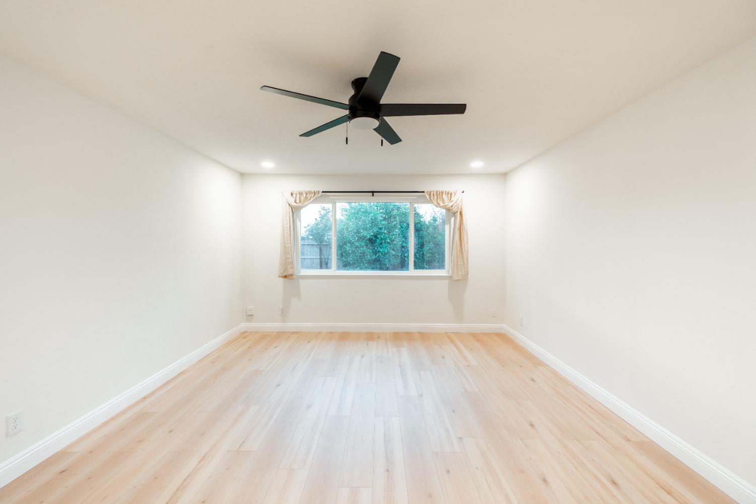 2612 Renn Avenue Clovis, CA 93611 - Photo 4 of 36 an empty room with wooden floor fan and windows