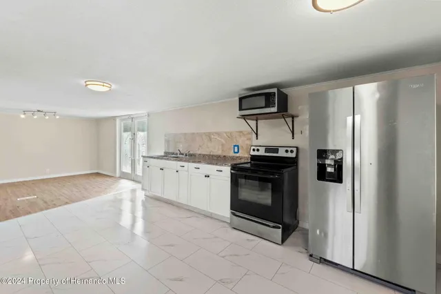 a kitchen with stainless steel appliances granite countertop a refrigerator and a stove