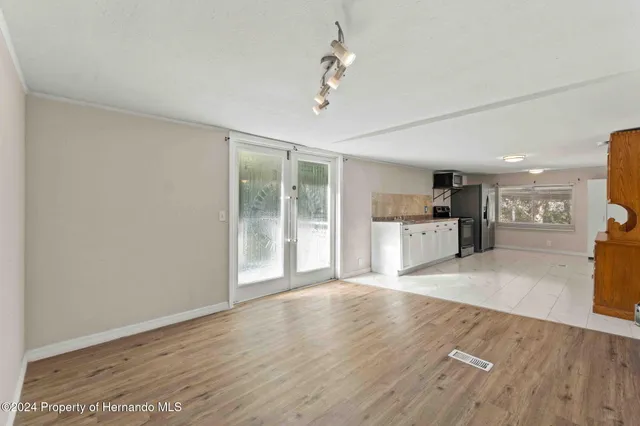 a view of a kitchen with wooden floor and a kitchen space