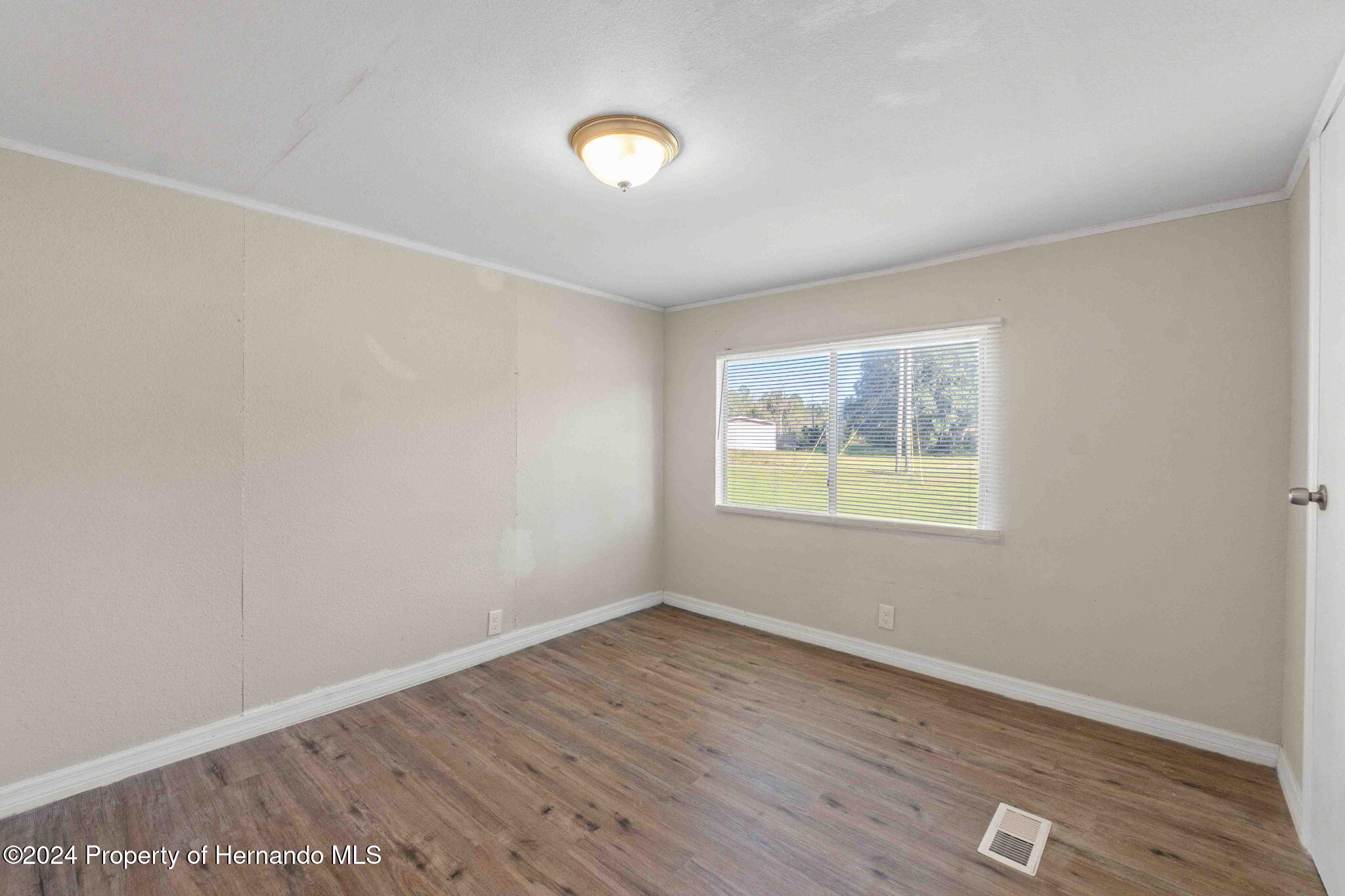 4265 North Beginning Path Crystal River, FL 34428 - Photo 22 of 30 an empty room with wooden floor and windows