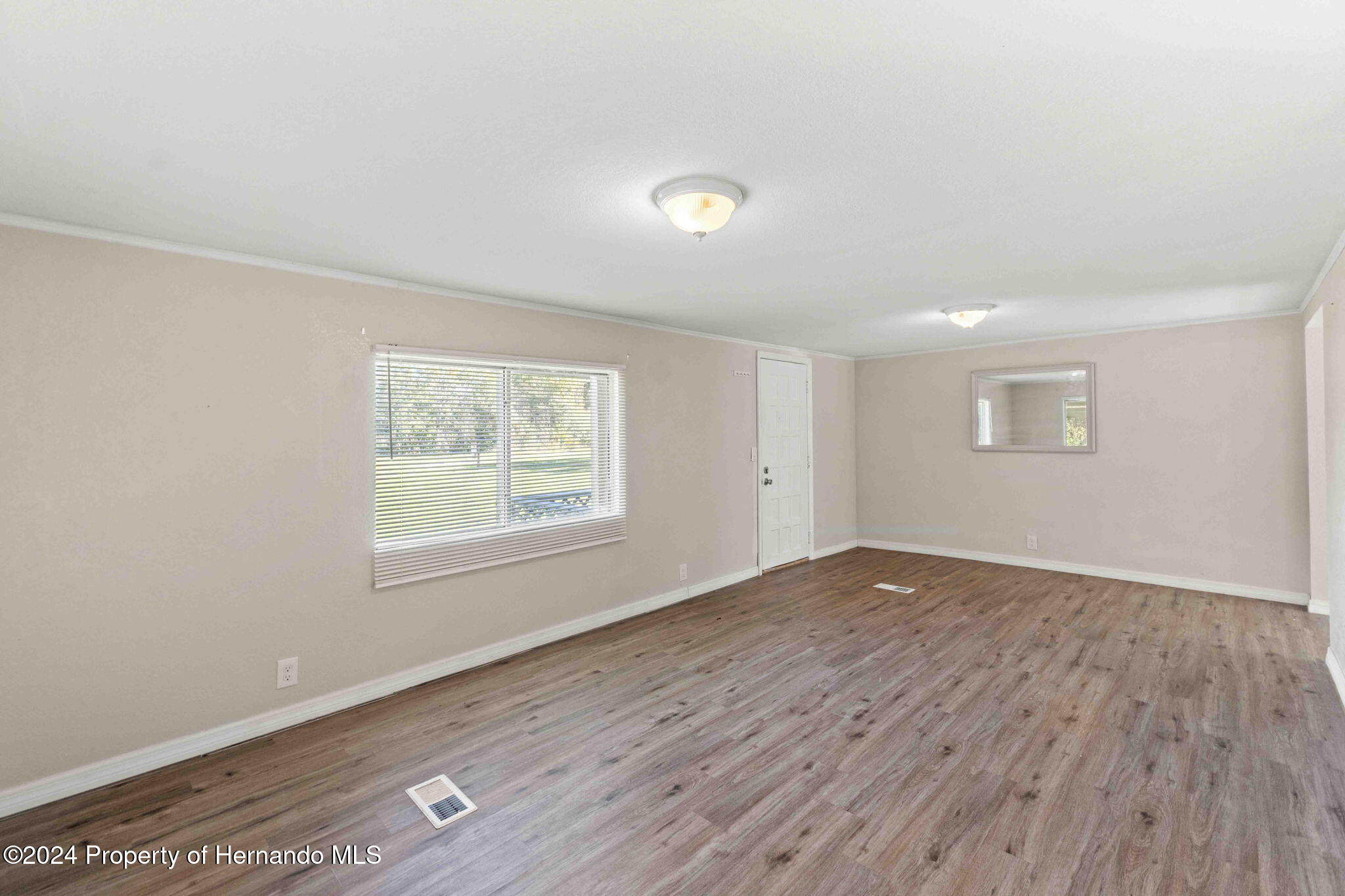4265 North Beginning Path Crystal River, FL 34428 - Photo 6 of 30 an empty room with wooden floor and windows