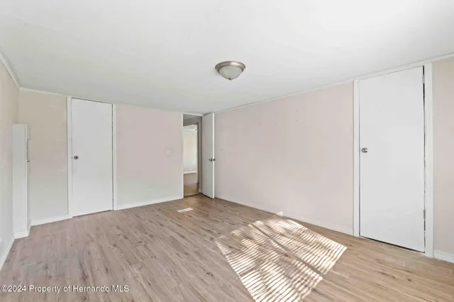 a view of an empty room with wooden floor