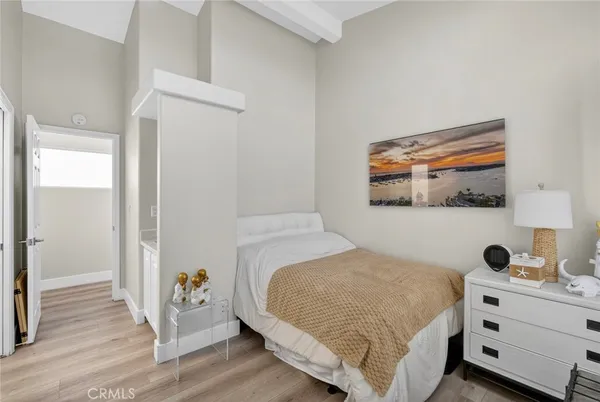 a bedroom with a bed and a flat tv screen on dresser