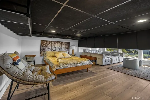 a bedroom with bed and glass walk in closet