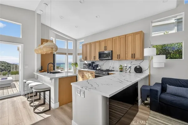 a kitchen with a stove a sink dishwasher a dining table and chairs with wooden floor