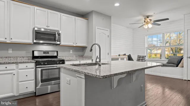 a kitchen with stainless steel appliances granite countertop a sink stove and cabinets