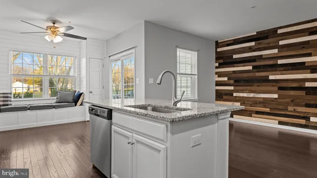 a kitchen with a sink stove and wooden floor