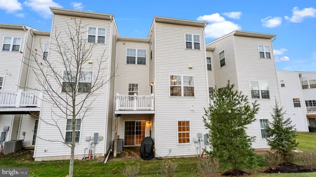a view of a white house next to a yard