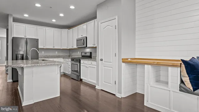 a kitchen with a refrigerator stove and white cabinets