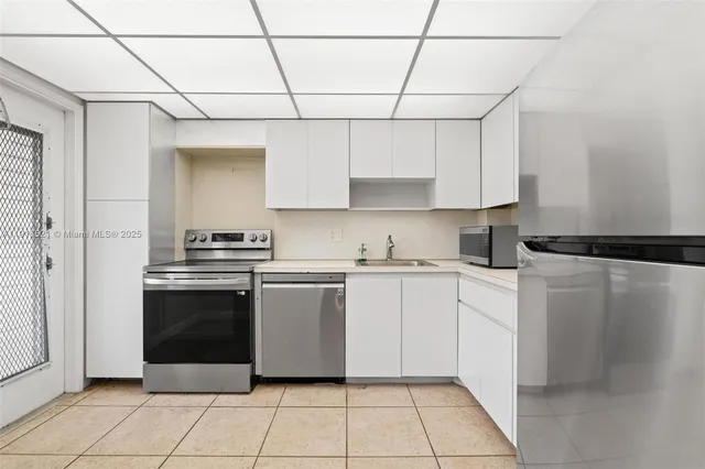 a kitchen with a stove sink and cabinets