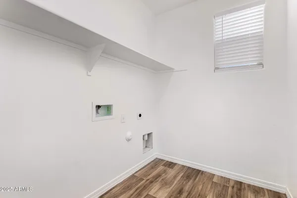 a view of a small space with wooden floor and a window