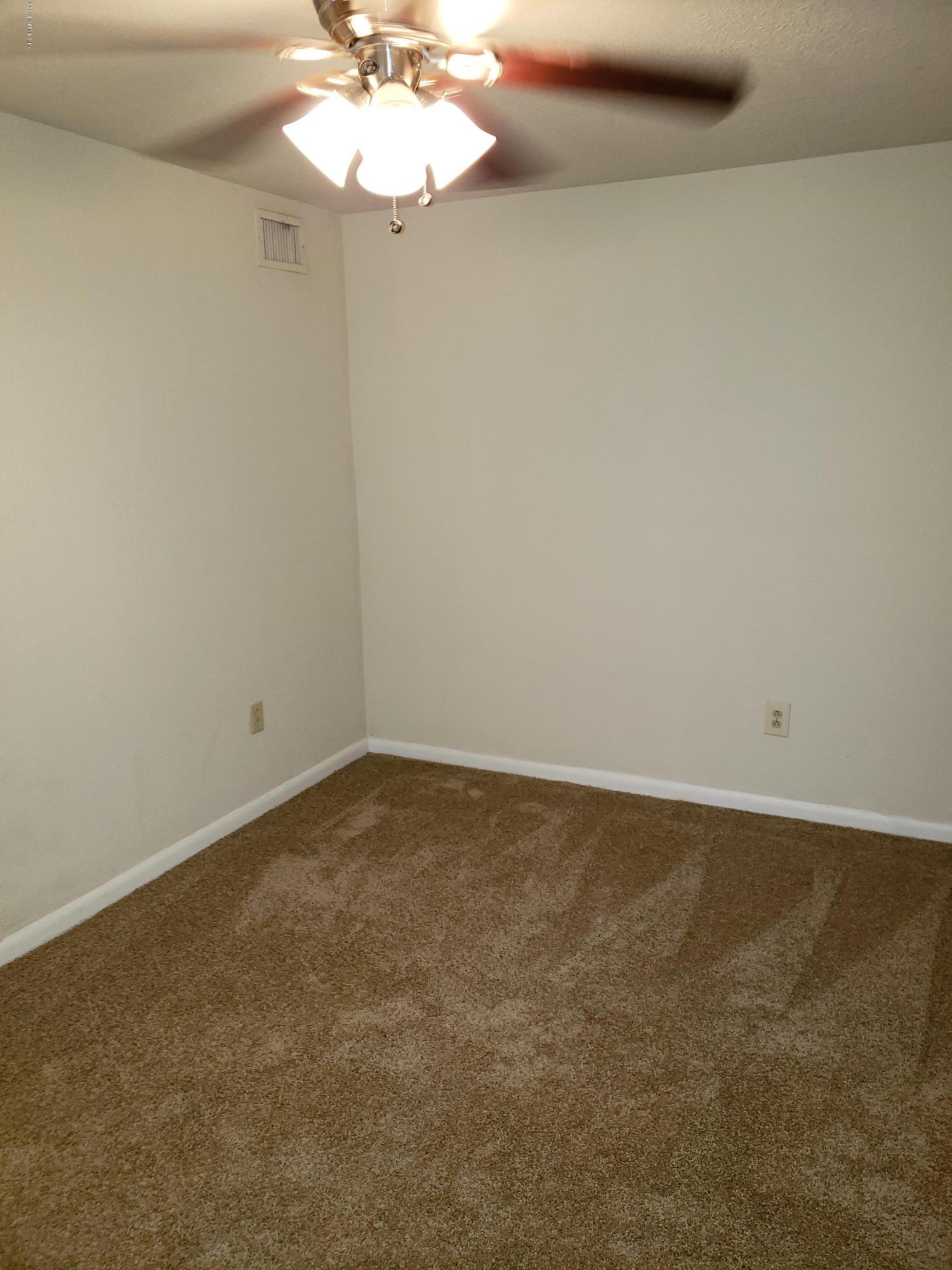 7110 Oakney Road Jacksonville, FL 32211 - Photo 11 of 15 a view of an empty room with a chandelier fan