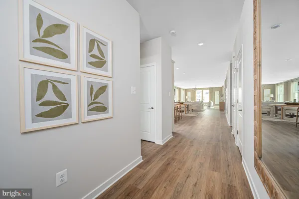 a view of a hallway with wooden floor and a living room