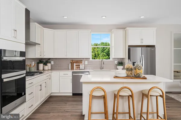 a kitchen with white cabinets appliances and a window