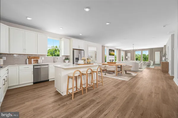 a kitchen with white cabinets a table and chairs