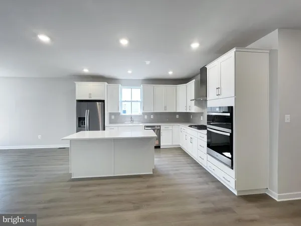 a open kitchen with white cabinets and stainless steel appliances