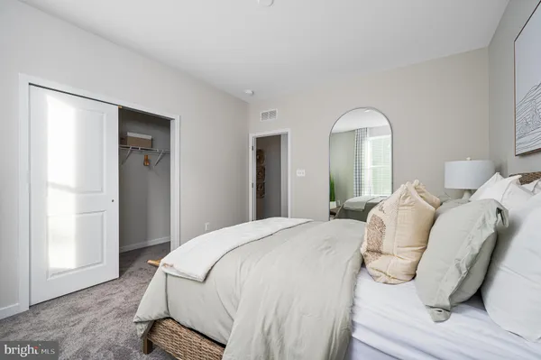 a large bed sitting in a bedroom and a mirror