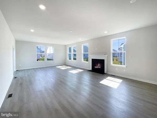 an empty room with windows and fireplace