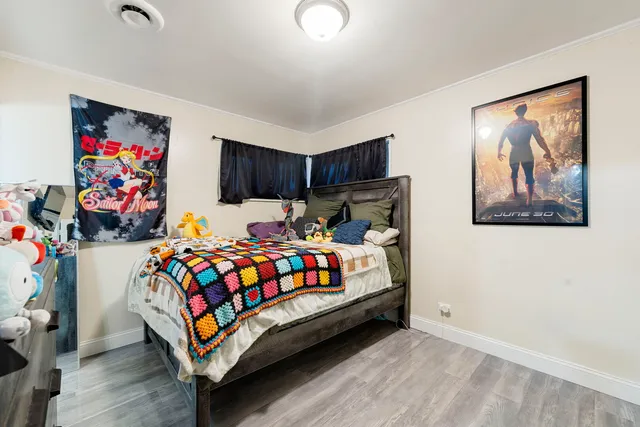 a bedroom with bed and wooden floor