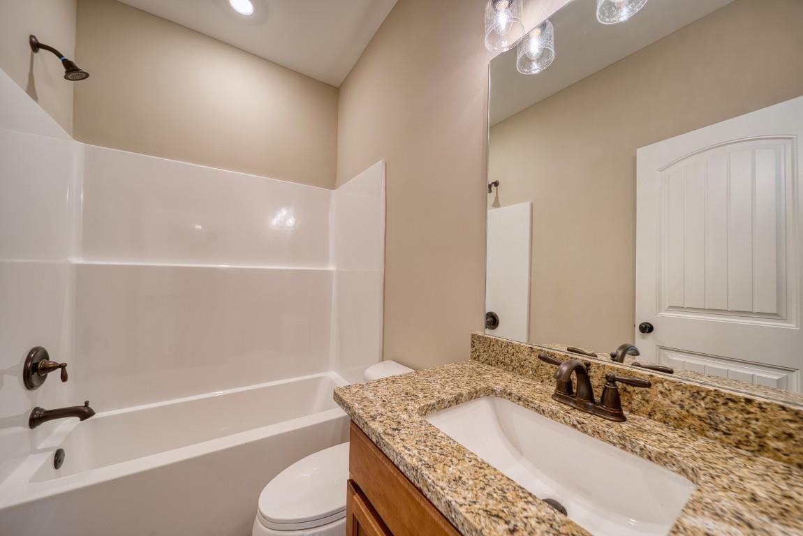 159 Como Lane Atoka, TN 38004 - Photo 17 of 38 a bathroom with a granite countertop bathtub sink vanity mirror and toilet