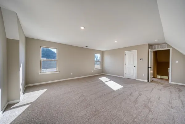 a view of an empty room with window and closet area