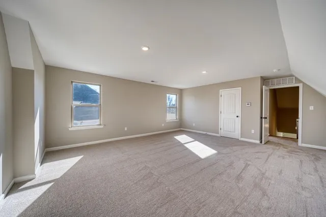 a view of an empty room with window and closet area