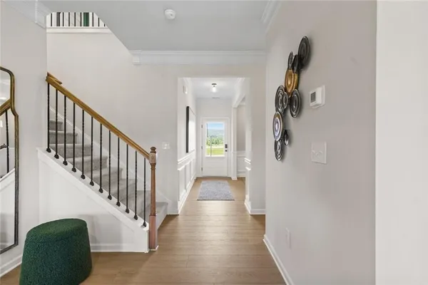 a view of a hallway with wooden floor and staircase