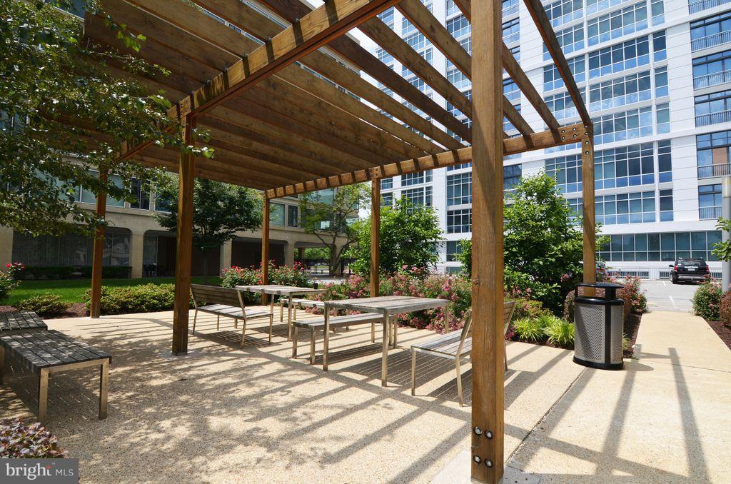 1101 3rd Street Southwest, Unit 305 Washington, DC 20024 - Photo 14 of 15 a view of a patio with a table and chairs and potted plants