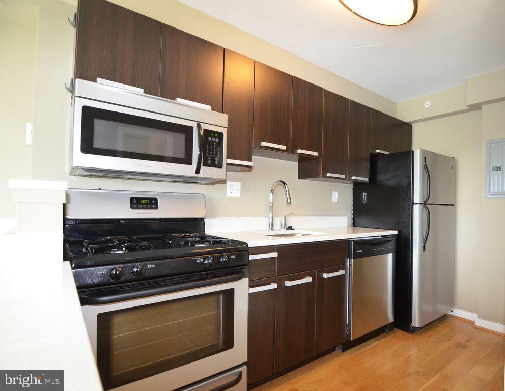 1101 3rd Street Southwest, Unit 305 Washington, DC 20024 - Photo 5 of 15 a kitchen with stainless steel appliances a stove microwave and refrigerator